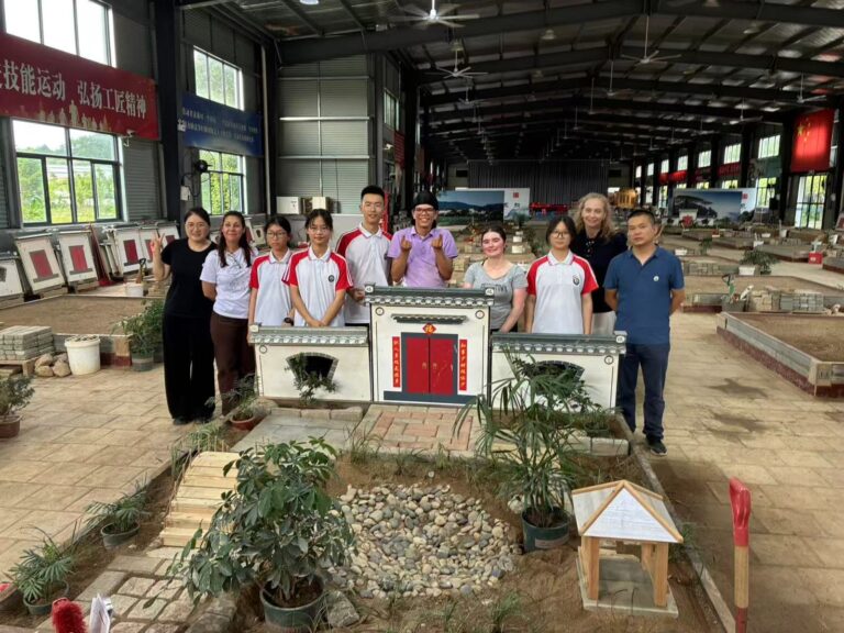 School visit in Anhui Province Students and teachers behind a scale model of a traditional courtyard house